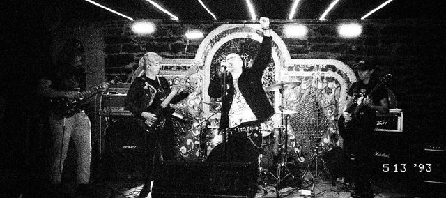 a black and white photo of the band recall playing on a stage
